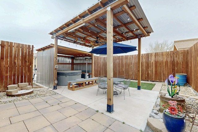 view of patio featuring a gazebo, outdoor dining area, a fenced backyard, and a hot tub