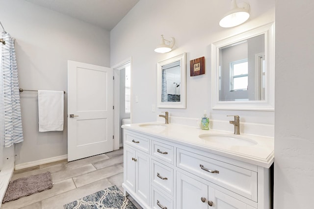 full bathroom featuring double vanity and a sink