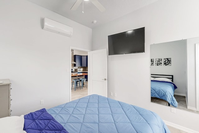 bedroom featuring a wall unit AC, ceiling fan, and baseboards