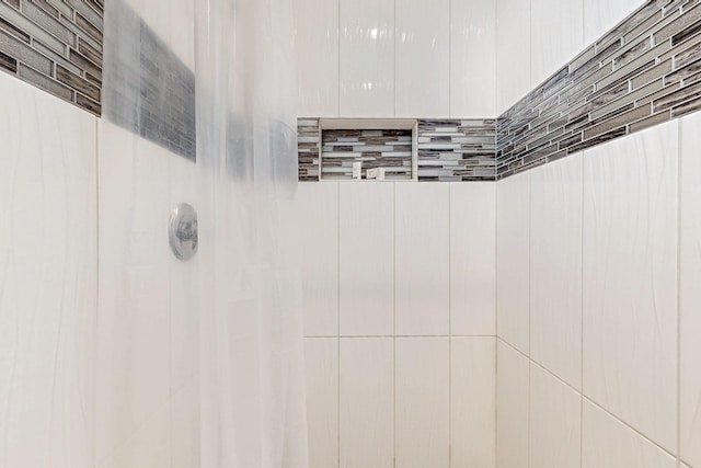 interior details featuring tiled shower