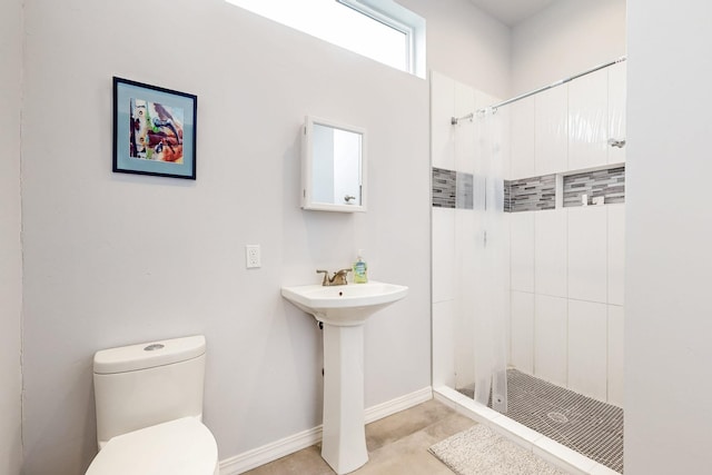 full bath with a stall shower, a sink, toilet, and baseboards