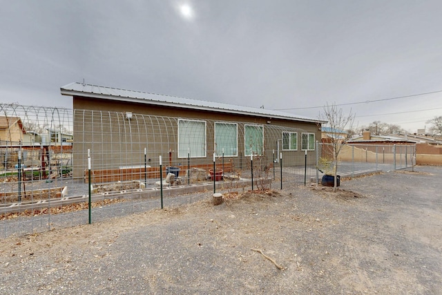 view of front of property with metal roof and fence