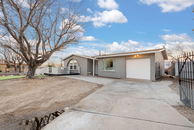 view of front of house with a garage, brick siding, driveway, and fence