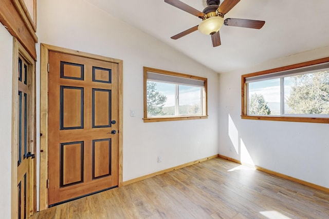 foyer featuring light wood-type flooring, ceiling fan, baseboards, and vaulted ceiling