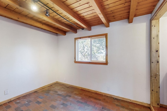 empty room featuring beam ceiling, brick floor, wood ceiling, and baseboards