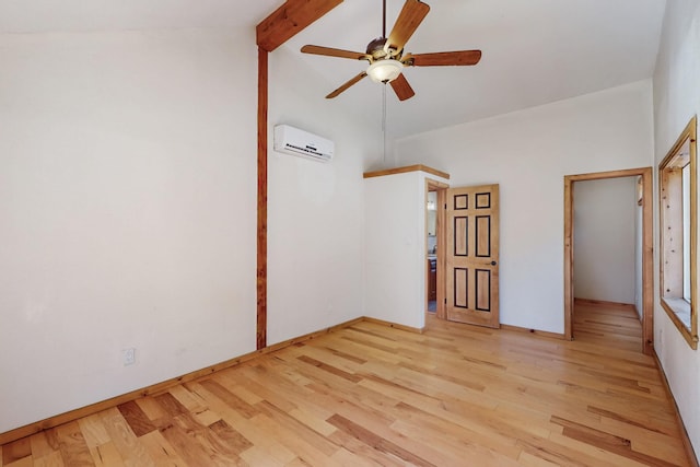 empty room featuring vaulted ceiling with beams, light wood finished floors, a ceiling fan, an AC wall unit, and baseboards