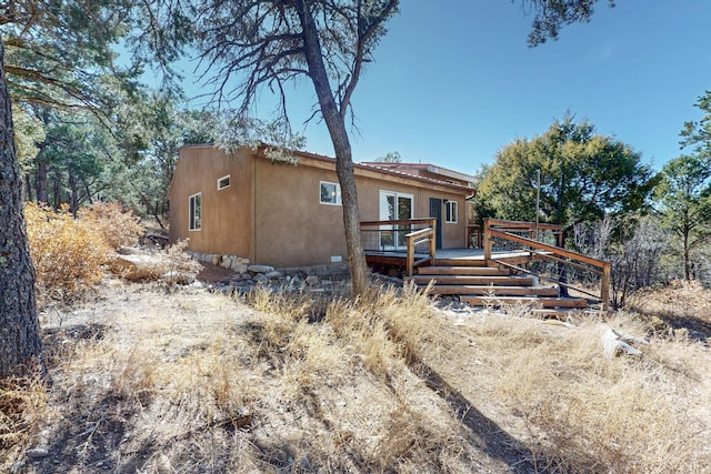 view of front of property featuring a deck and stucco siding