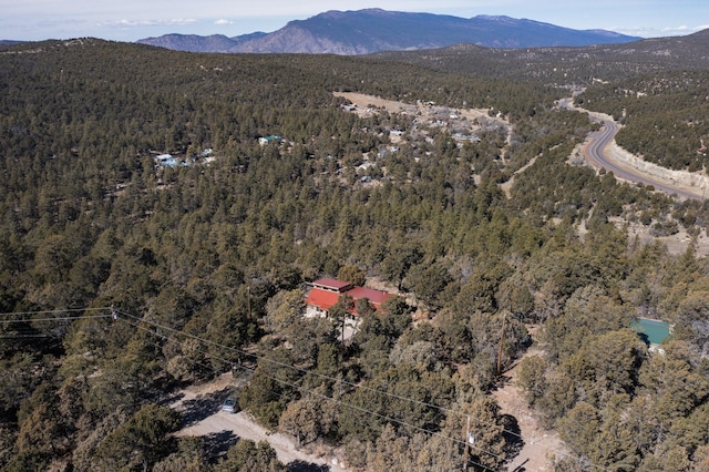 birds eye view of property featuring a wooded view and a mountain view