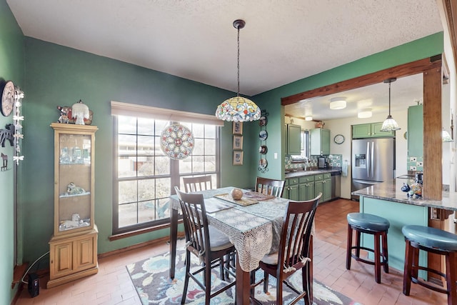 dining space with brick floor and a textured ceiling