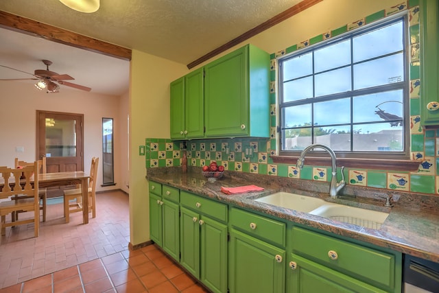 kitchen featuring dark countertops, light tile patterned flooring, a sink, a textured ceiling, and green cabinetry