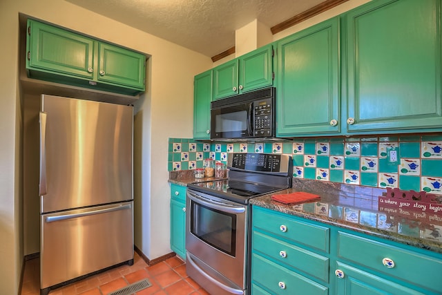 kitchen featuring stainless steel appliances, visible vents, backsplash, light tile patterned flooring, and dark stone counters