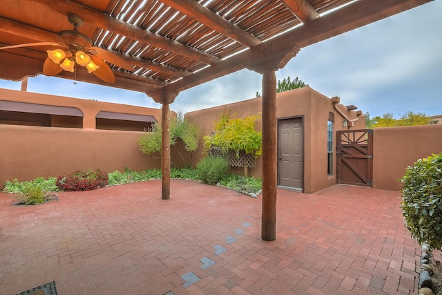 view of patio / terrace featuring a ceiling fan, a gate, fence, and a pergola