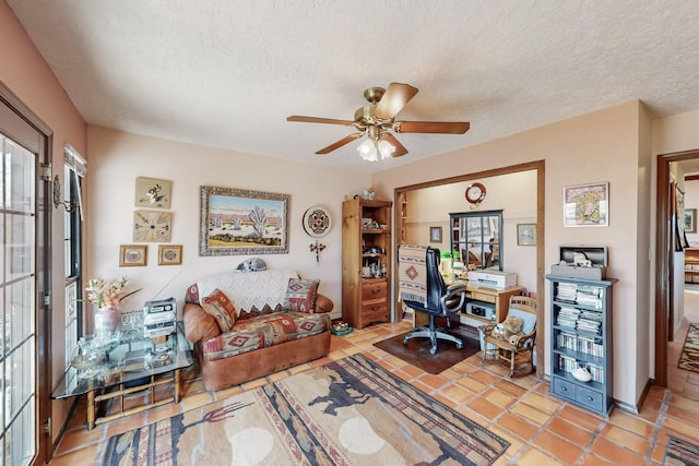 office space with light tile patterned floors, a ceiling fan, and a textured ceiling