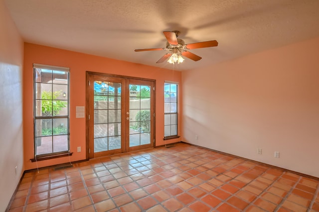 doorway featuring a ceiling fan, visible vents, plenty of natural light, and a textured ceiling