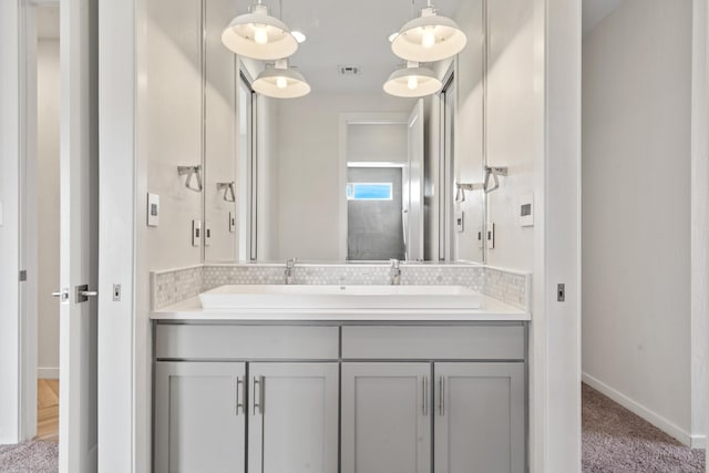 bathroom with visible vents, vanity, and baseboards