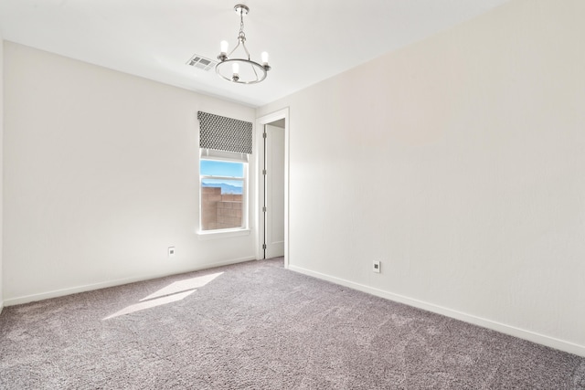 carpeted spare room featuring an inviting chandelier, visible vents, and baseboards