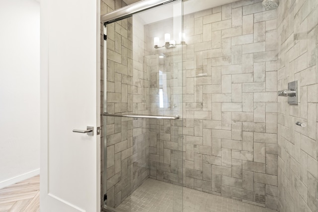 full bathroom featuring a stall shower and baseboards