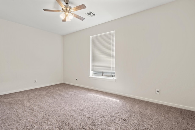 carpeted spare room with a ceiling fan, visible vents, and baseboards