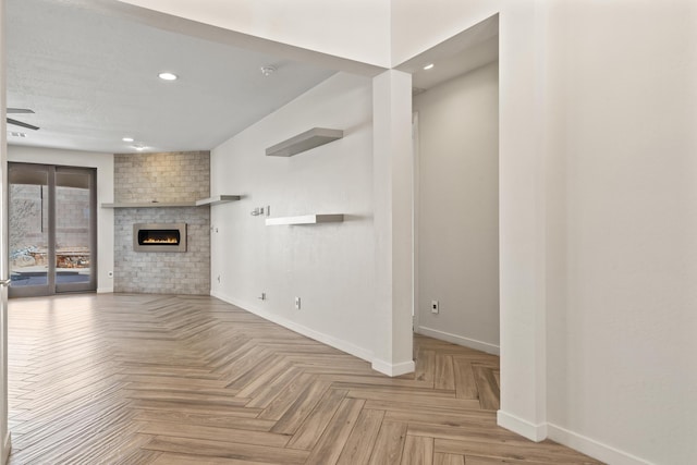 unfurnished living room featuring a fireplace, baseboards, and recessed lighting