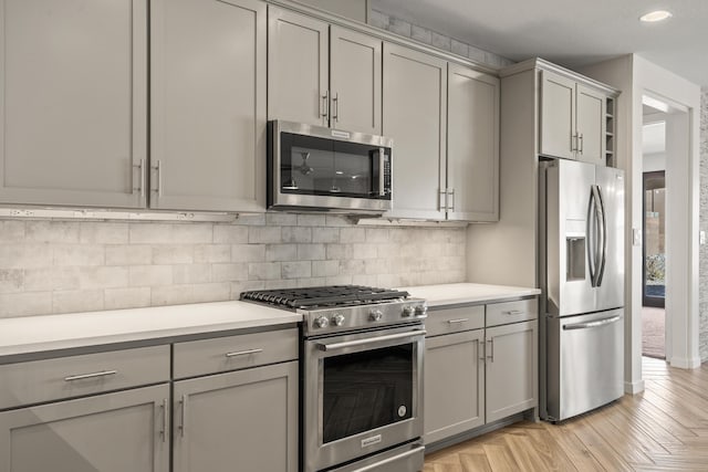 kitchen with stainless steel appliances, light countertops, and gray cabinetry