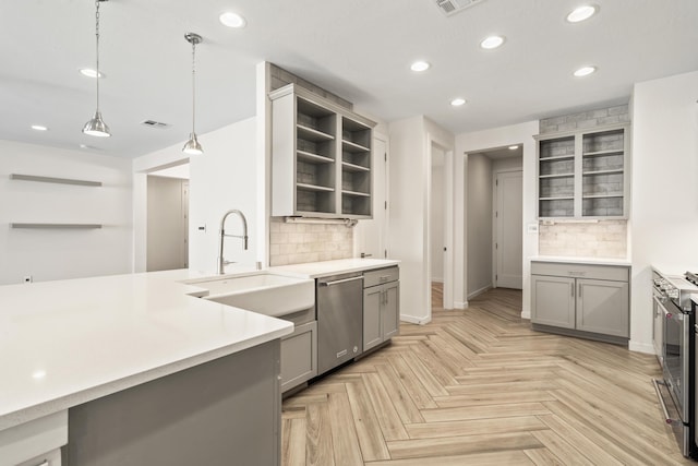 kitchen featuring gray cabinetry, light countertops, appliances with stainless steel finishes, open shelves, and decorative light fixtures