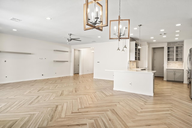 unfurnished living room featuring recessed lighting, visible vents, a ceiling fan, a sink, and baseboards