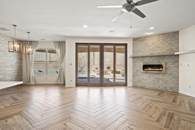 unfurnished living room with french doors, a brick fireplace, visible vents, and baseboards