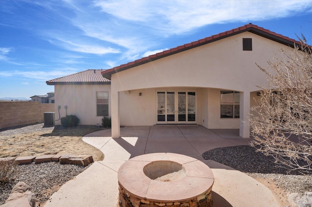 back of property with a patio, an outdoor fire pit, fence, and stucco siding