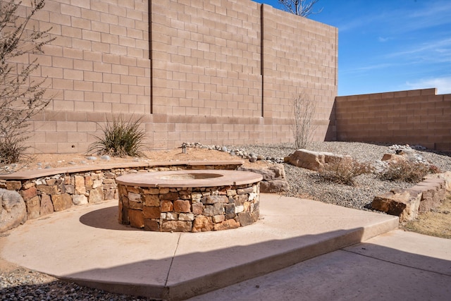 view of patio / terrace with a fire pit and fence