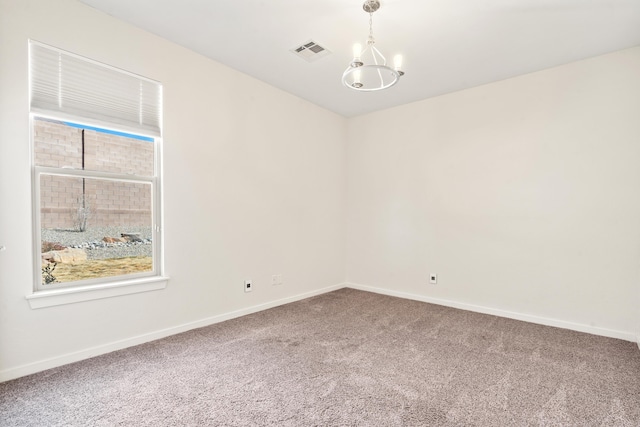 carpeted empty room with an inviting chandelier, baseboards, and visible vents