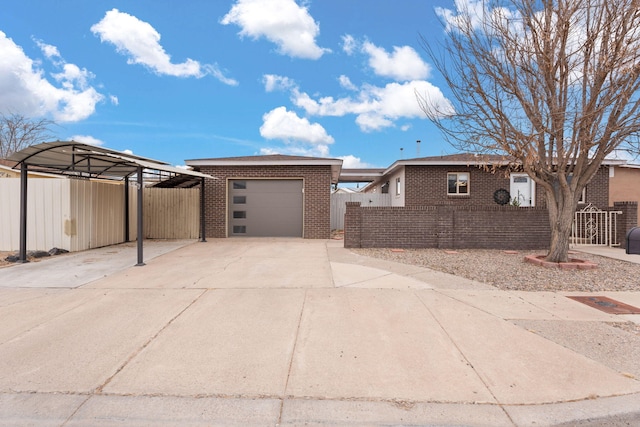 view of front of property with driveway, brick siding, an attached garage, and fence