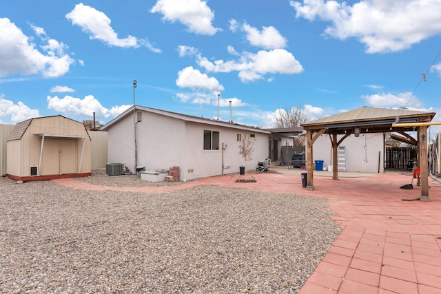 back of property with an outbuilding, a patio, a gazebo, stucco siding, and a storage unit