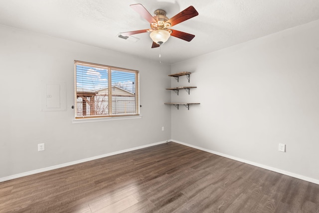 empty room with baseboards, visible vents, and dark wood-type flooring