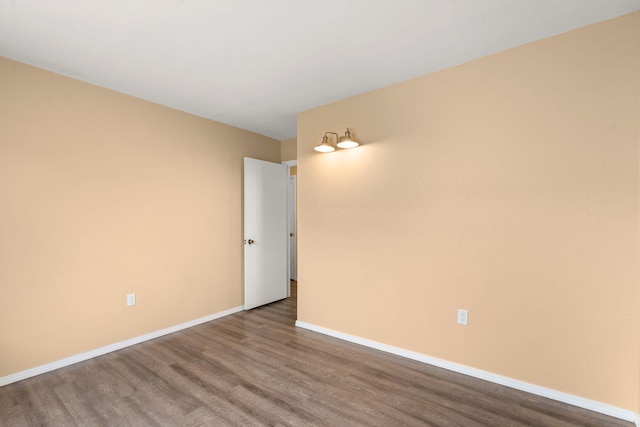 empty room featuring wood finished floors and baseboards