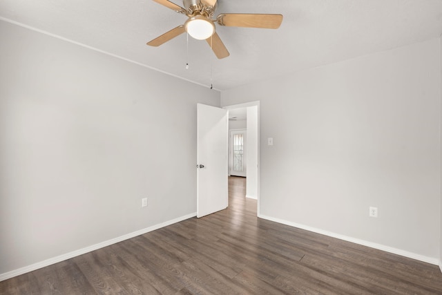 empty room featuring dark wood-type flooring, ceiling fan, and baseboards