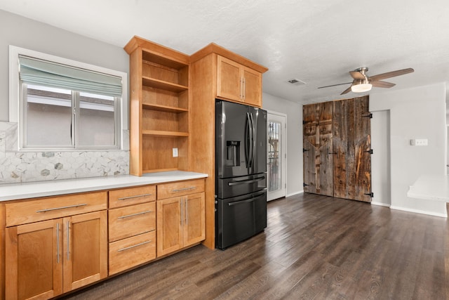 kitchen with dark wood-style floors, open shelves, black fridge, and light countertops