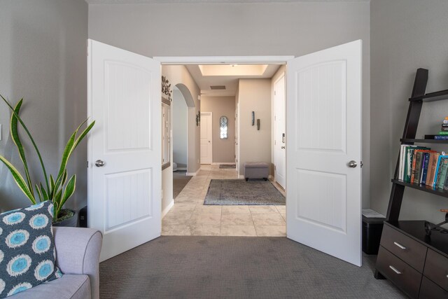 hall featuring carpet floors and arched walkways