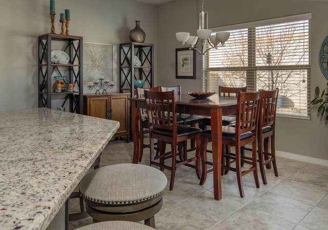 dining area featuring a notable chandelier, baseboards, and light tile patterned floors