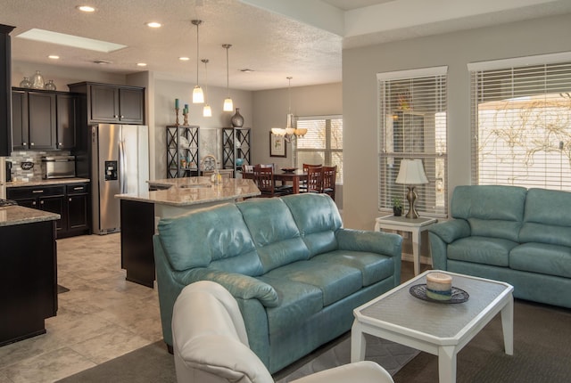 living area with a chandelier, a textured ceiling, and recessed lighting