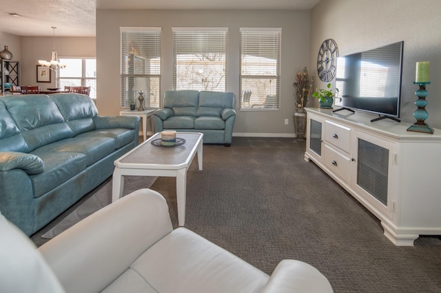 living area featuring baseboards, dark colored carpet, and a notable chandelier