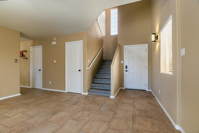 foyer entrance featuring stairs and baseboards