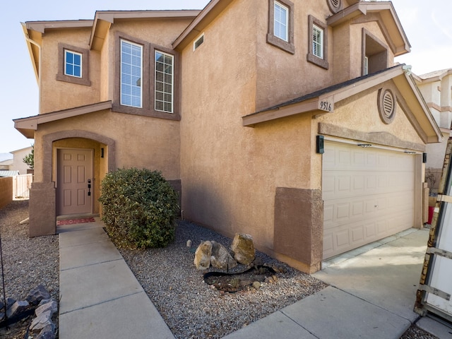 view of front facade with a garage, concrete driveway, and stucco siding