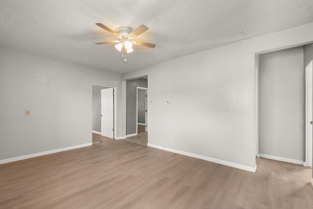 unfurnished room with ceiling fan, baseboards, and wood finished floors