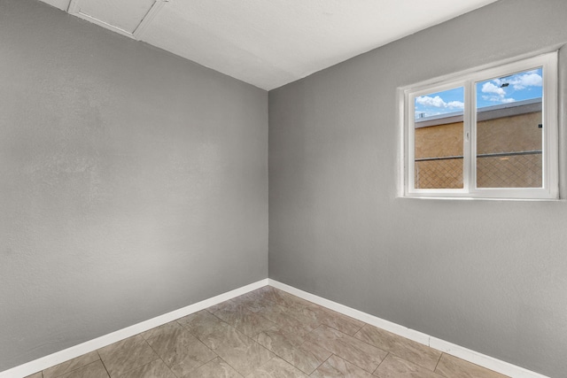 unfurnished room featuring baseboards