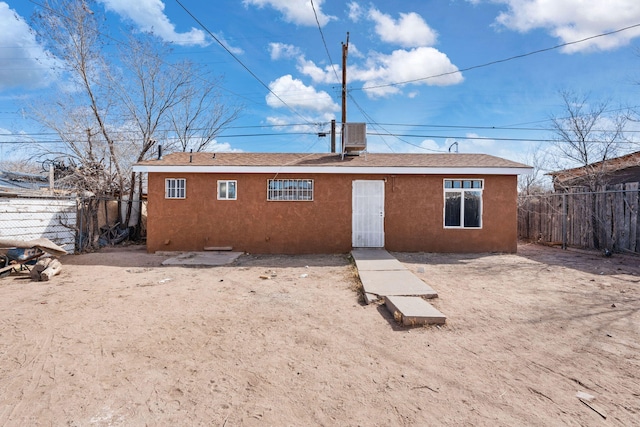 back of house with fence private yard and stucco siding