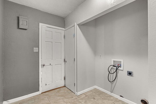 clothes washing area with hookup for a washing machine, baseboards, hookup for an electric dryer, and a textured wall