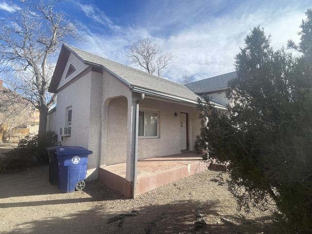 exterior space featuring roof with shingles and stucco siding