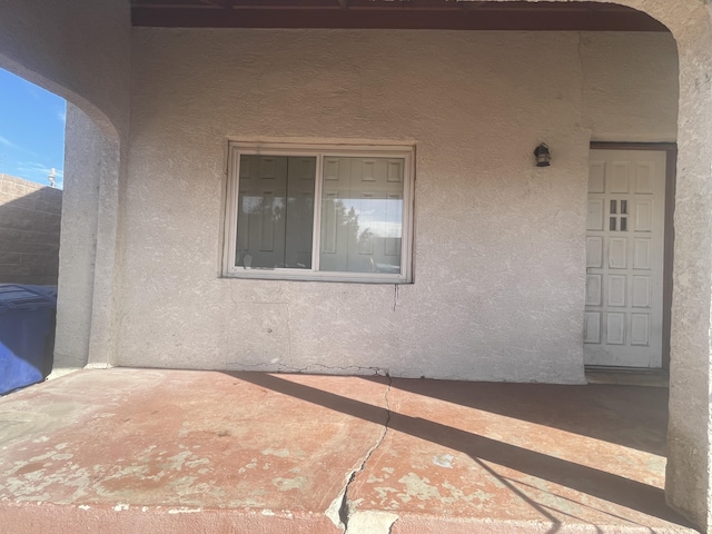 entrance to property featuring stucco siding