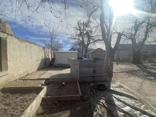 view of yard featuring a storage shed, a fenced backyard, and an outdoor structure