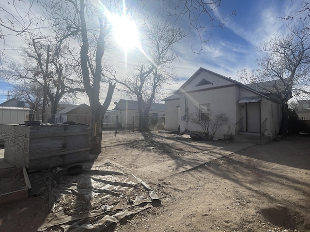 exterior space featuring entry steps, fence, and stucco siding